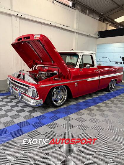 Chevrolet C10 roja con el cofre abierto mostrando el motor