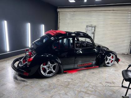 Volkswagen sedán negro con recubrimiento cerámico dentro del taller
