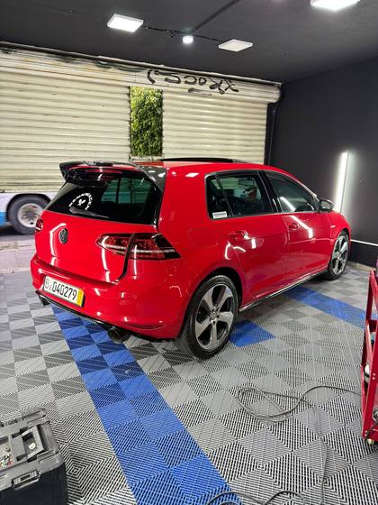 Golf GTI rojo visto desde atras dentro del taller