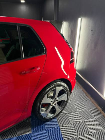 Costado de un Golf GTI rojo con rines pulidos