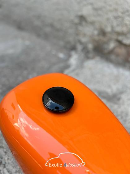 Tanque de motocicleta naranja recien pintado