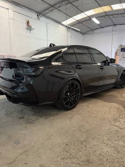 BMW M3 negro visto desde atras dentro del taller