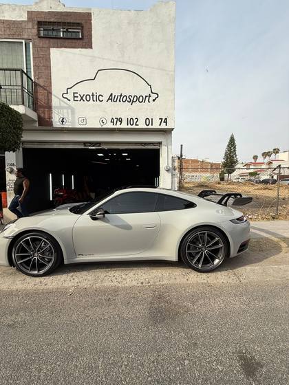 Porsche 911 992 Carrera gris terminado afuera del taller