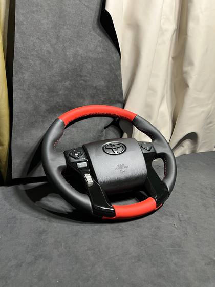 Volante forrado en piel negra con detalles en rojo